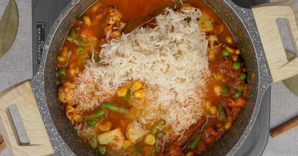 “Cooking basmati rice with vegetables and spices for easy vegetable biryani recipe until fully cooked and fluffy”