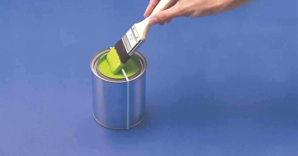 A DIY paint can cleaner made using a simple household setup, showing a paint can being wiped and cleaned efficiently with a tool, organized workspace with painting supplies, realistic home improvement scene