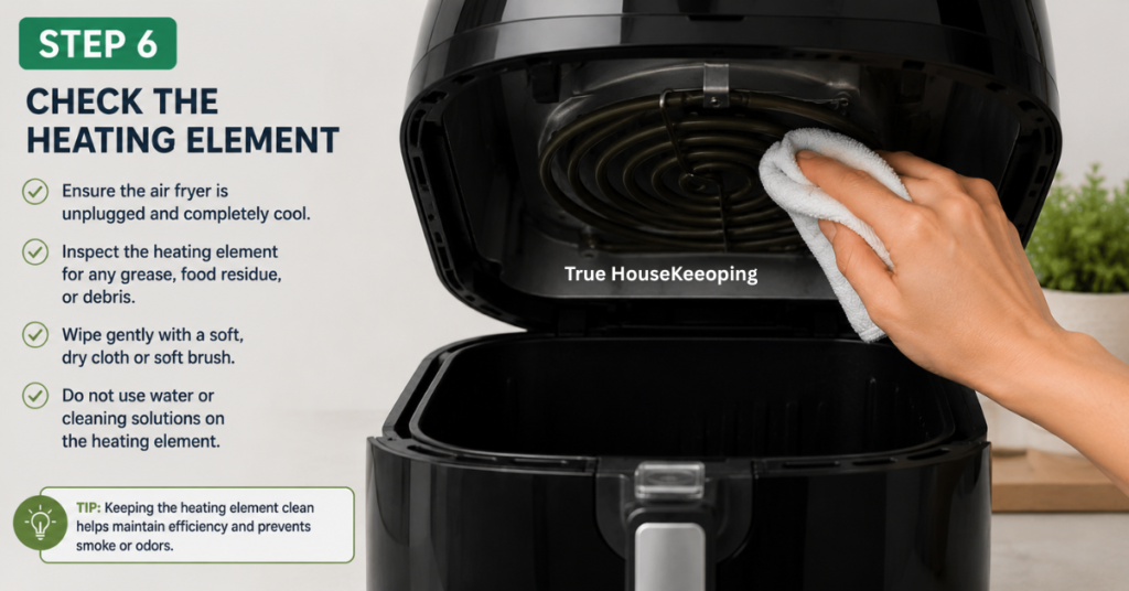Person gently cleaning the heating element inside an air fryer with a soft microfiber cloth after the appliance has cooled.