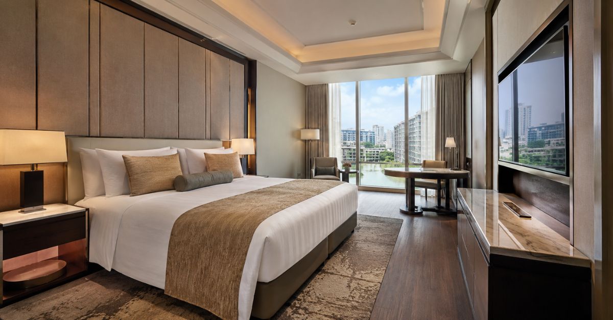 Modern clean hotel room prepared for guests with fresh linens and organized furnishings.