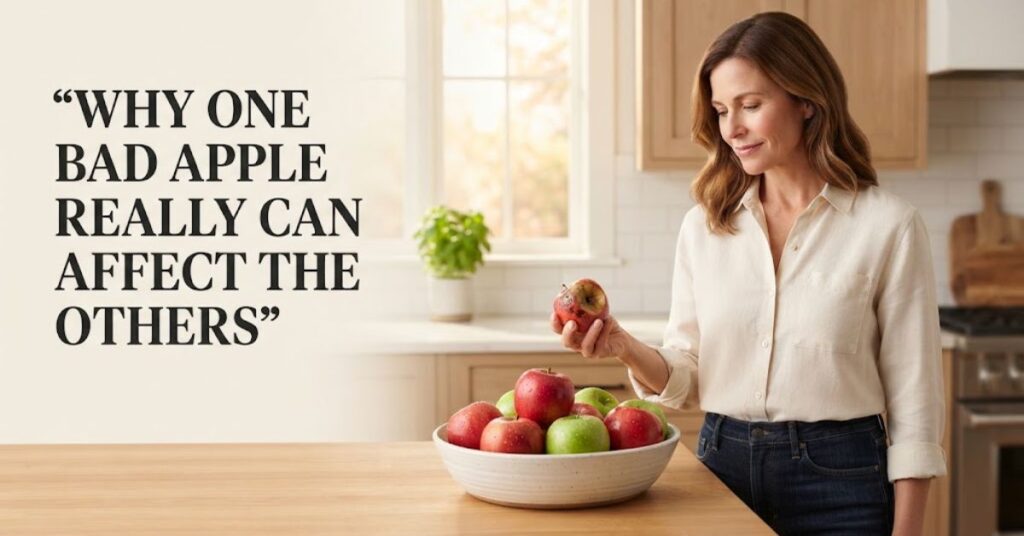 Woman removing a damaged apple from a basket of fresh apples